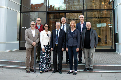 Eine Gruppe von Personen steht vor dem Eingang des Neubaus