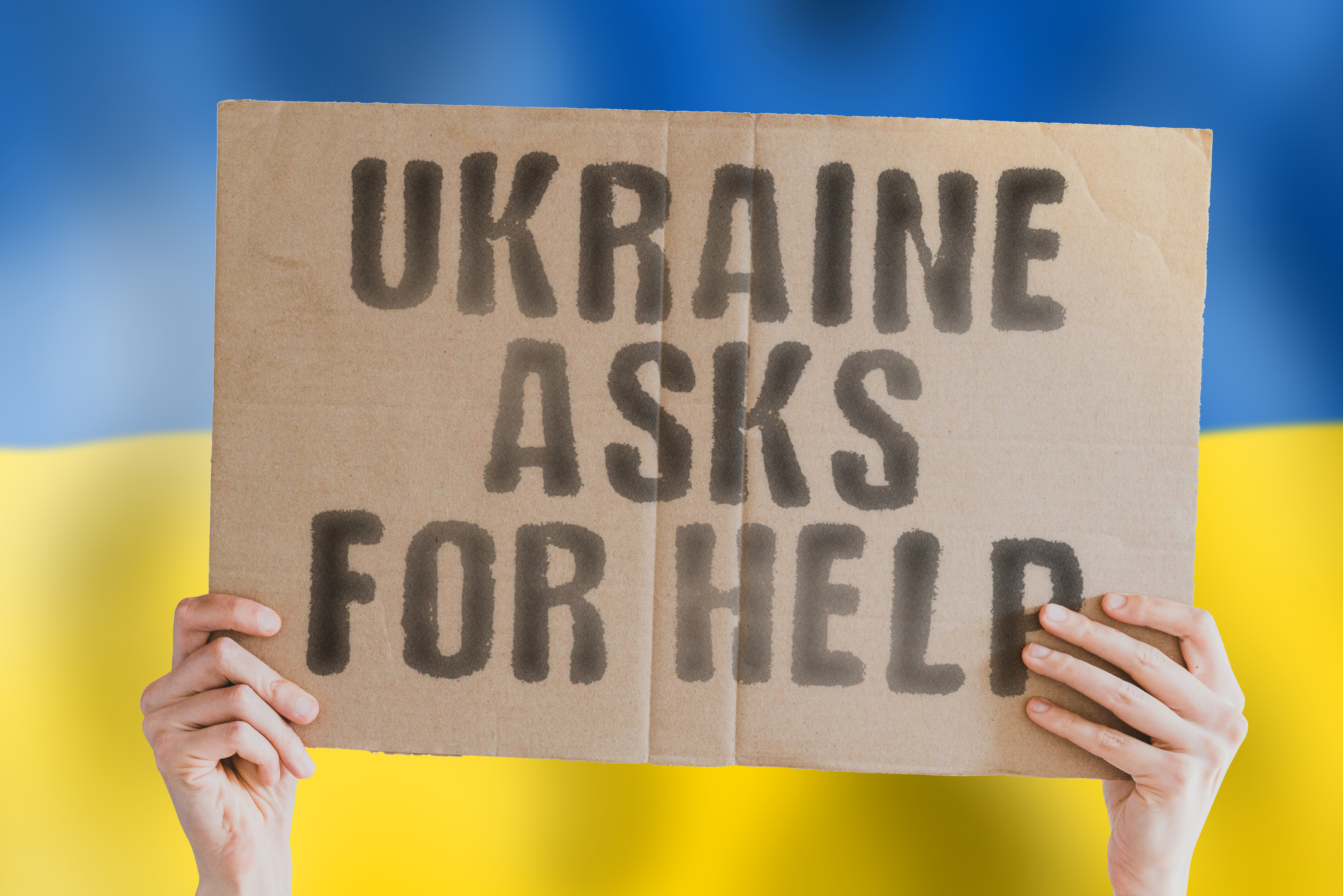 Foto: AndriiKoval auf stock.adobe.com Ukraine asks for help: Schriftzug auf einer hochgehaltenen Pappe